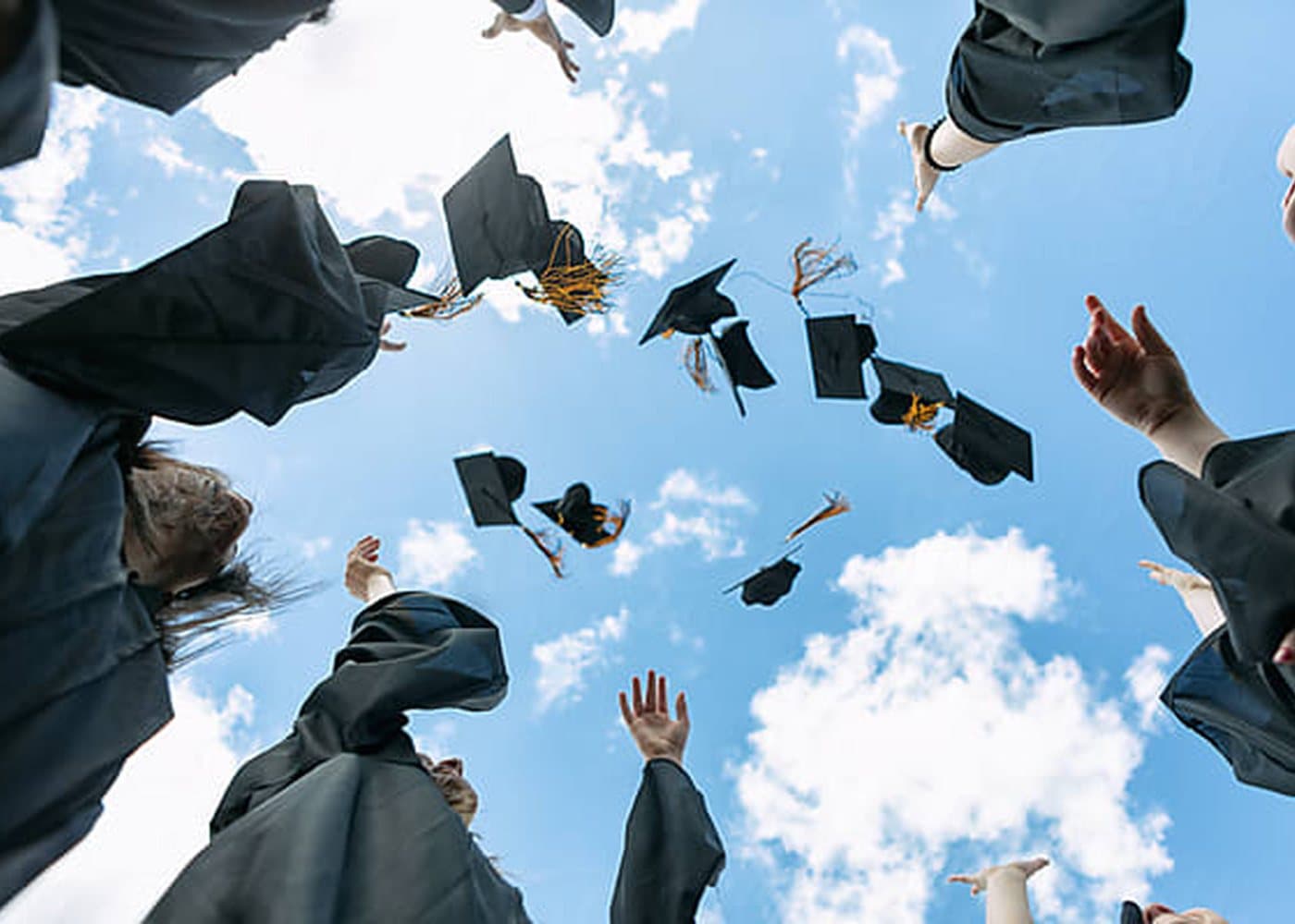 Graduating students tossing caps into the sky
